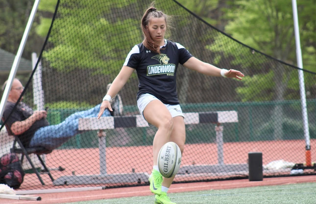 Makenna Bailey kicking a rugby ball for Lindenwood University
